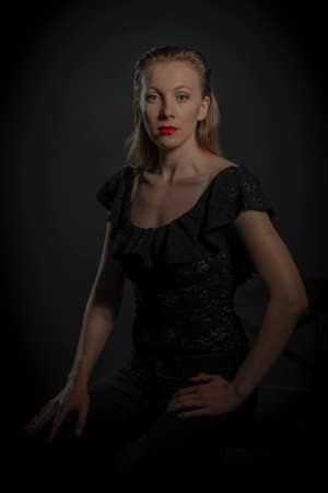 portrait of a girl with blonde hair on a black backgroundの写真素材