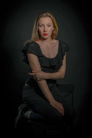 portrait of a girl with blonde hair on a black backgroundの写真素材