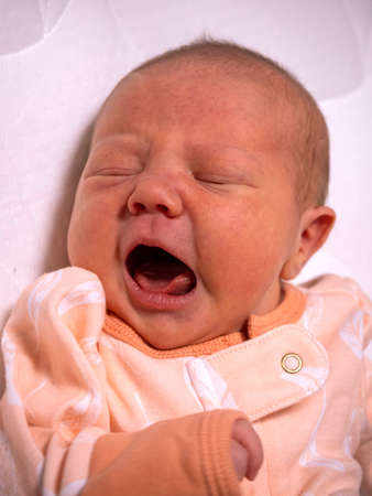a small child a baby is lying in a crib and does not sleepの写真素材