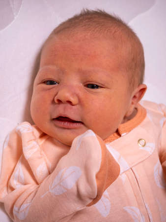 a small child a baby is lying in a crib and does not sleepの写真素材