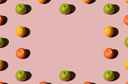 Colorful summer fruit pattern made of fresh organic green apples, lemons and mandarin oranges on...
