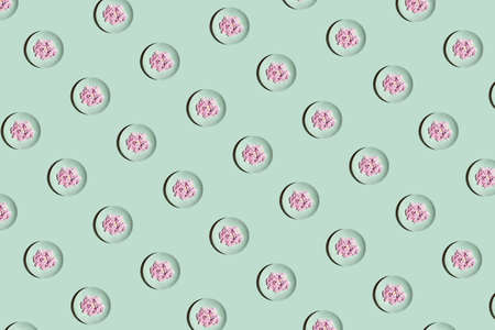 Minimalistic pattern concept with mint plates and pink bright flowers on pastel background. Geometric colorful composition.の写真素材