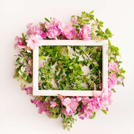 Colorful summer concept with bright pink flowers, green leaves and white frame. Minimalistic flat...