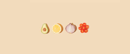 Minimalistic composition with raw organic avocado, lemon, onion and cherry tomato on pastel beige...