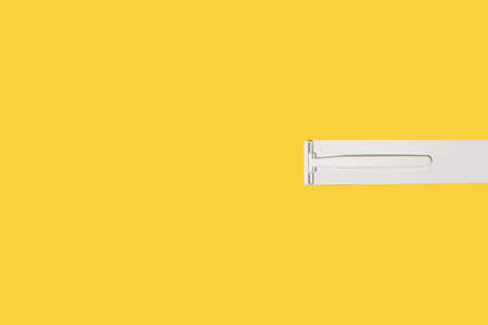 Minimal creative concept with a razor and illuminating background. White and yellow geometric...