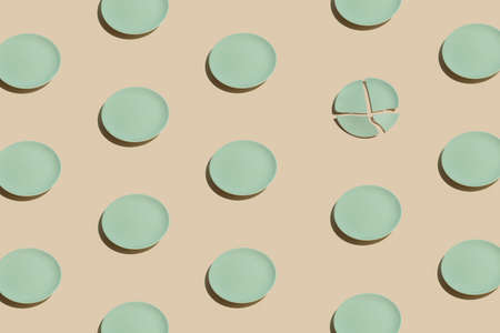 Minimalistic irregular pattern arrangement with mint green plates against pastel beige background....
