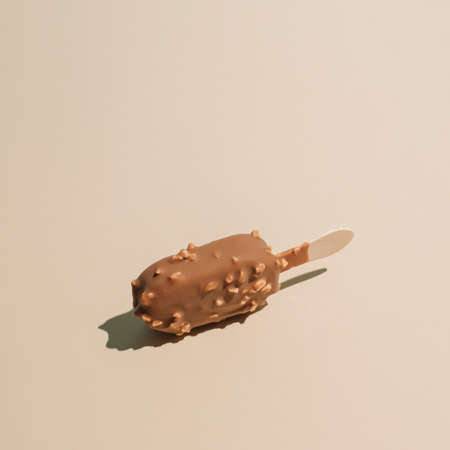 Minimalistic isolated chocolate ice cream concept, pastel beige background. Creative summer vibes...