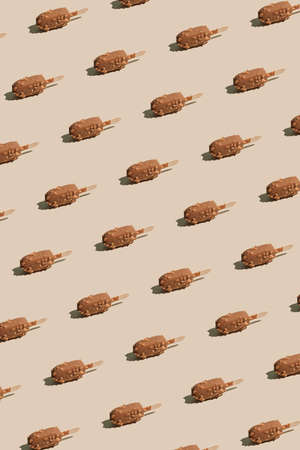 Creative summer vibes pattern with isolated chocolate ice cream on pastel beige background....