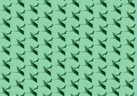 Minimal monochromatic pattern concept with green origami cranes. Festive aesthetic visualization, creative craft and decoration idea.の写真素材