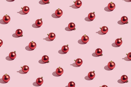 Visual Christmas and New Year decoration idea with red baubles against bright pink background. Minimal pattern composition, creative aesthetic shadow concept.の写真素材
