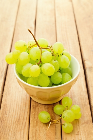 Grapes in bowl over wooden backgroundの写真素材