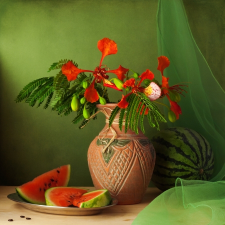 Still life with water melon and red flowers over green backgroundの写真素材