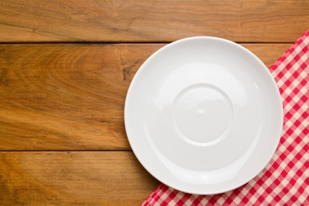 Empty plate on wooden tabletop with tableclothの写真素材