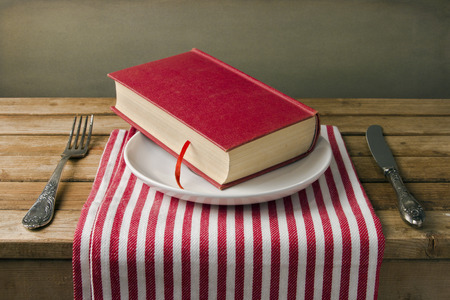 Book on plate with knife and fork. Table arrangement.の写真素材