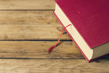 Background with red book and wooden deck tableの写真素材