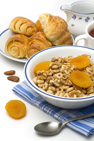 Breakfast cereal with croissant and dry apricot on white backgroundの写真素材