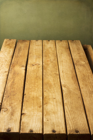 Wooden deck tabletop against grunge wallの写真素材
