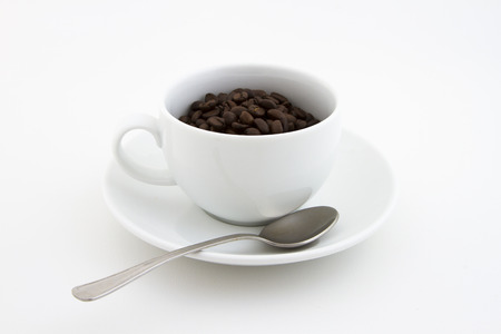 White coffee cup with spoon and coffee beans on white backgroundの写真素材