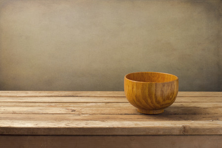 Empty wooden dish on table over grunge wallの写真素材