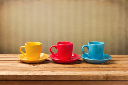 Three colorful coffee cups over vintage backgroundの写真素材
