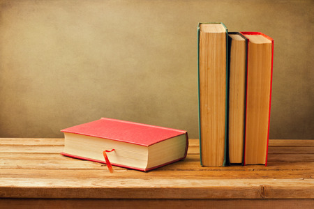 Vintage old books on wooden deck tabletop against grunge wallの写真素材