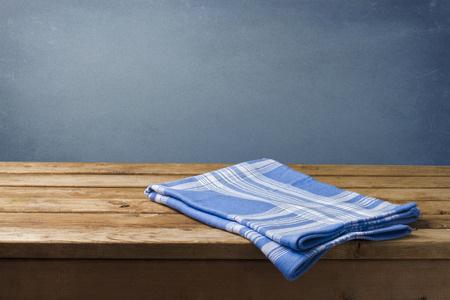 Background with wooden table, tablecloth and grunge blue wallの写真素材