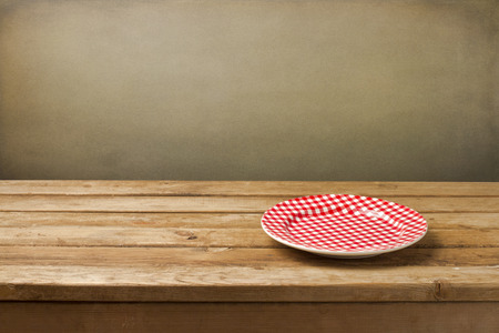 Empty plate on wooden table over grunge backgroundの写真素材