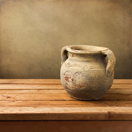 Vintage ceramic jug on wooden table over grunge backgroundの写真素材