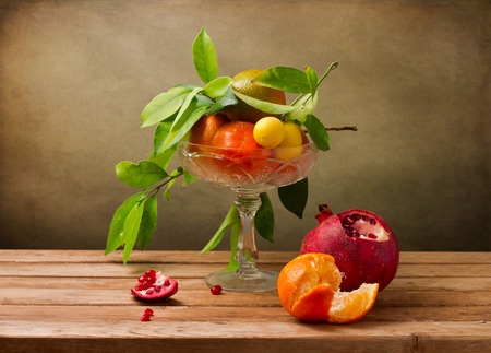 Still life with crystal vase with fruits on wooden tableの写真素材