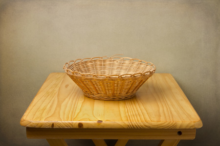 Empty basket on wooden table over grunge backgroundの写真素材