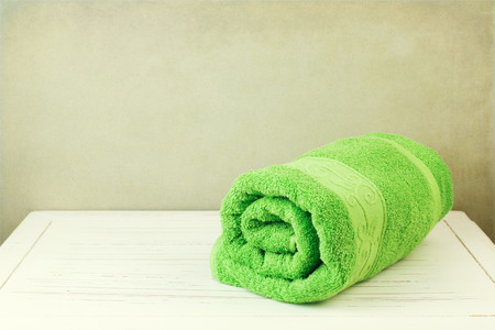 Fresh clean towel on white wooden table over grunge backgroundの写真素材
