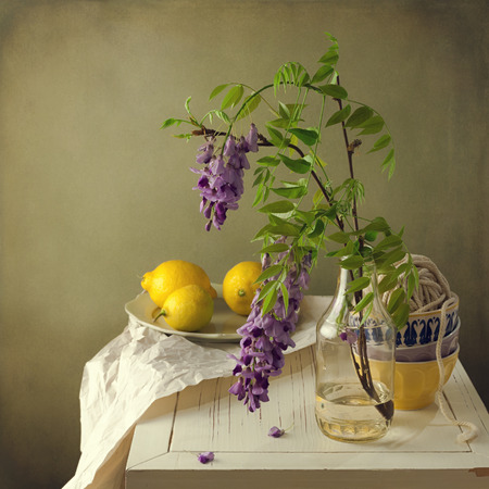 Still life with spring flowers and lemons on white wooden tableの写真素材