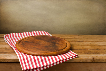 Wooden board stand on tablecloth over grunge backgroundの写真素材
