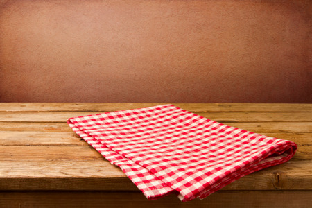 Retro background with wooden table and tablecloth over red rough wallの写真素材