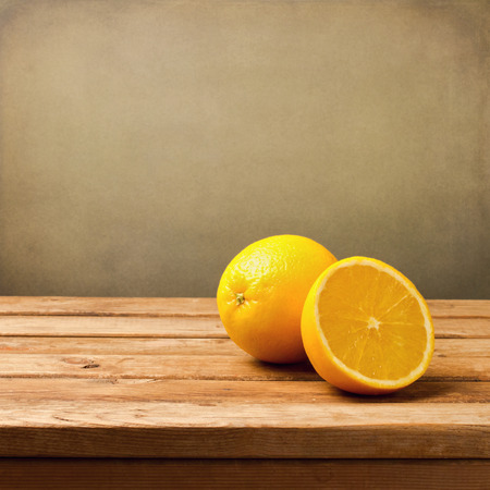 Orange fruit on wooden vintage table over grunge backgroundの写真素材