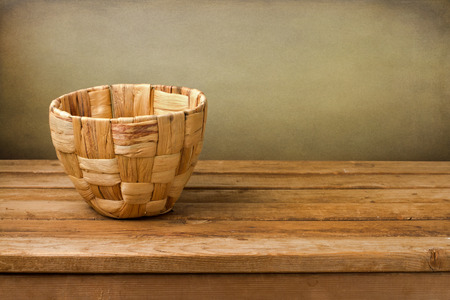 Empty basket on wooden deck table over grunge backgroundの写真素材