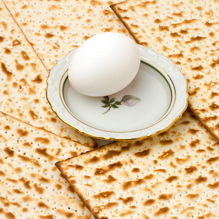 Background with matzo and egg on plate