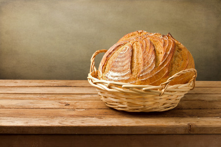 Fresh bread in basket on wooden vintage table
