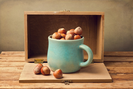 Hazelnuts in cup over wooden backgroundの写真素材