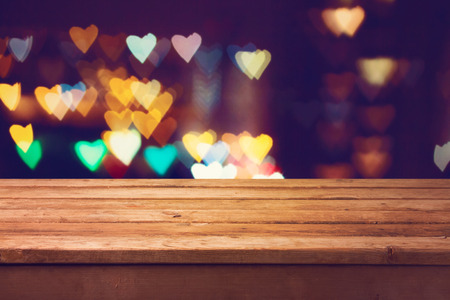 Vintage wooden deck table over heart bokeh backgroundの写真素材
