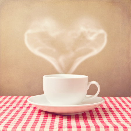 Coffee cup with heart shape steam over grunge backgroundの写真素材