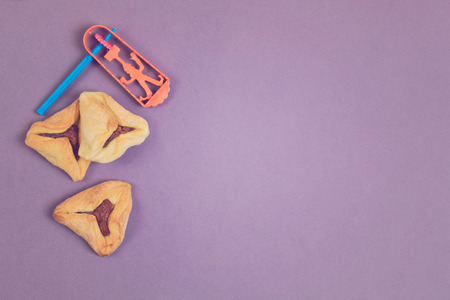 Hamantaschen cookies with grogger on purple background with copy spaceの写真素材