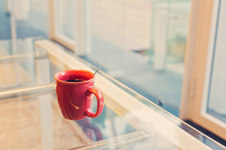 Coffee cup in the office on glass tableの写真素材