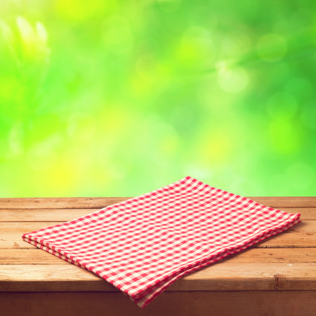 Empty wooden table with tablecloth over bokeh backgroundの写真素材