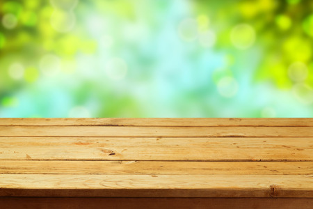 Empty wooden deck table over garden bokeh backgroundの写真素材