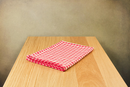 Wooden table with tablecloth over grunge backgroundの写真素材