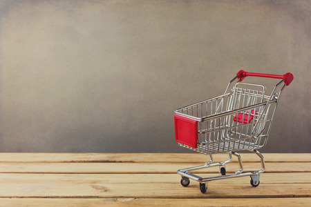 Shopping cart on wooden surfaceの写真素材