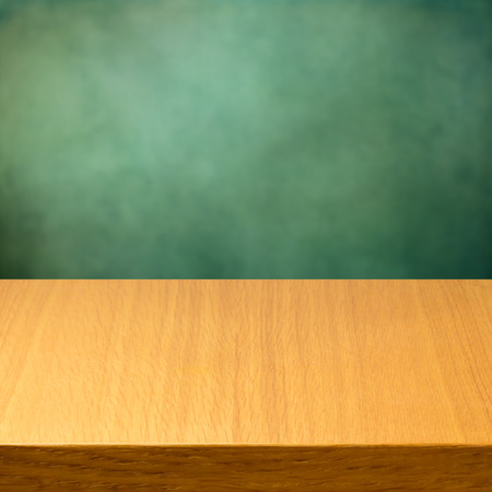 Empty wooden modern table over green backgroundの写真素材