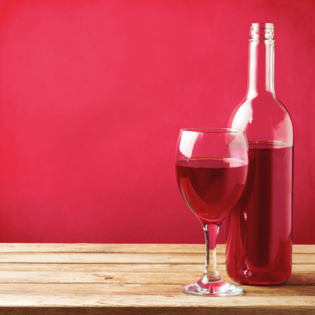 Wine glass with bottle on wooden tableの写真素材