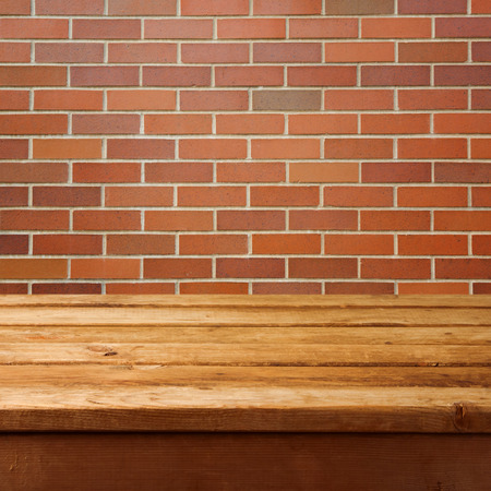 Wooden table and brick wall の写真素材